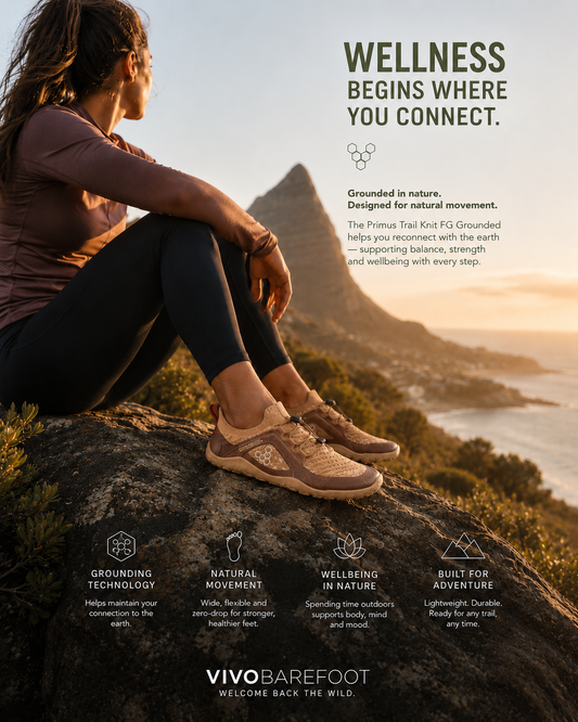 Woman wearing brown Vivobarefoot Primus Trail Knit FG Grounded barefoot trail shoes overlooking the Cape coastline at sunset, promoting wellness and grounding.