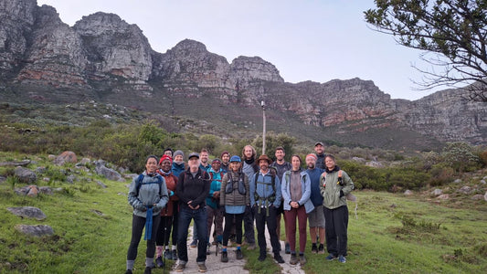 Participants on a Grounded Guides hiking adventure in Cape Town, standing beneath the Twelve Apostles mountains while exploring natural movement, foot strength and the outdoors with VivoOutsider guides