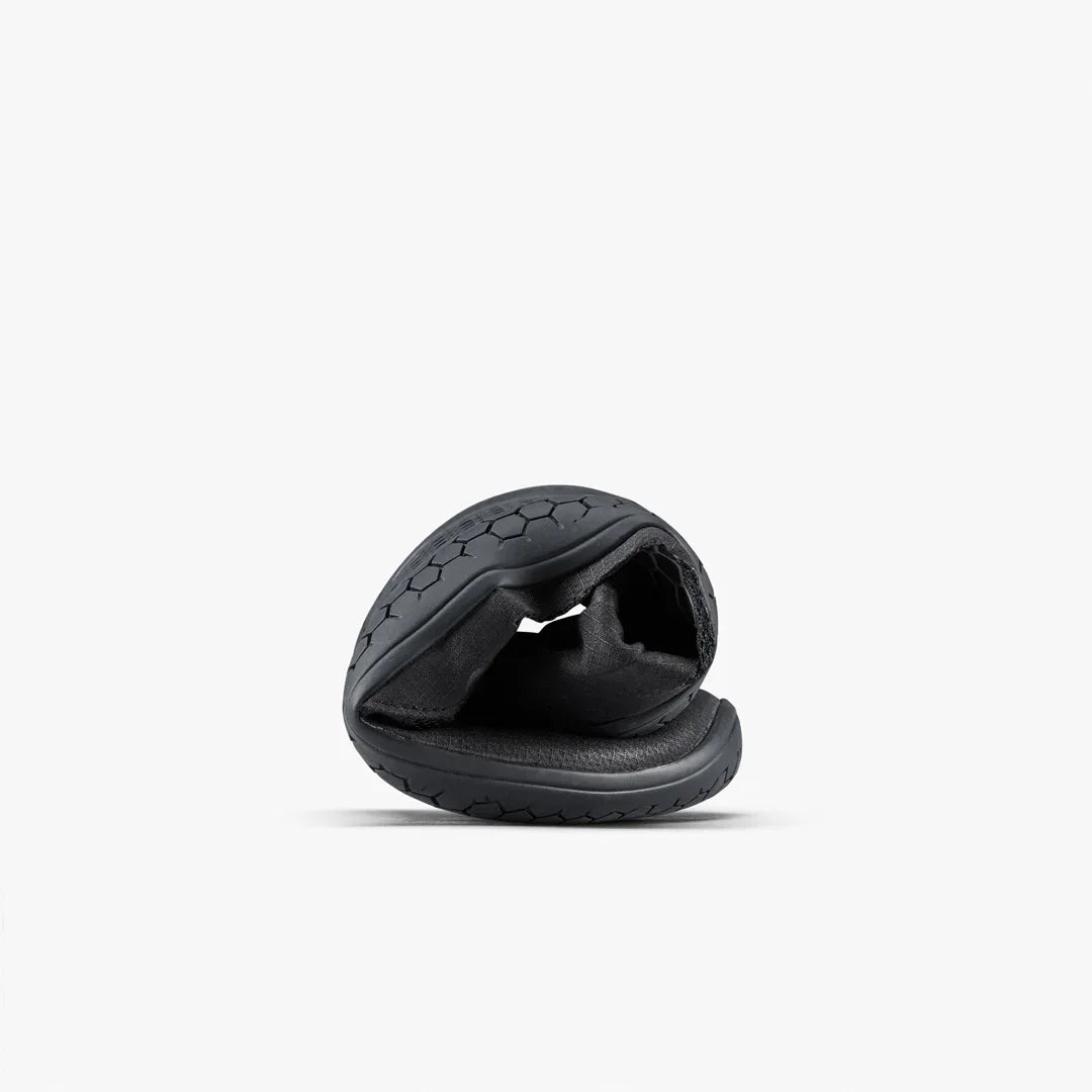 Black dog toy with textured surface on a white background