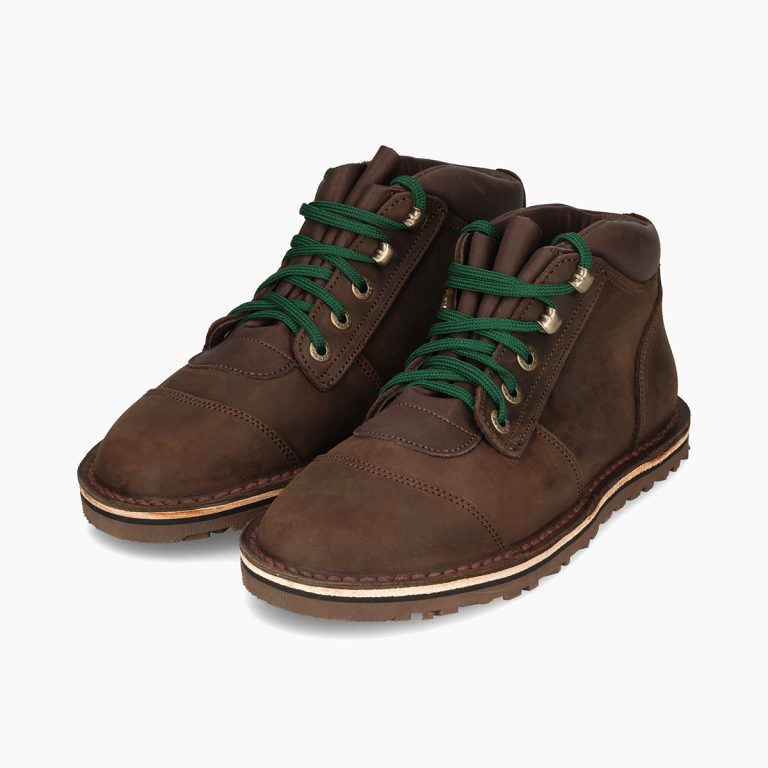 Pair of brown leather boots with green laces on a white background