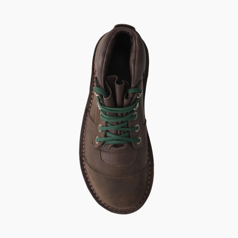 Brown leather boot with green laces on a white background