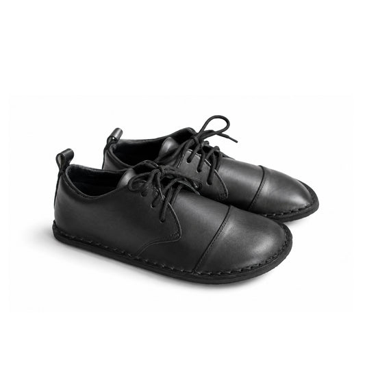A pair of black leather lace-up shoes with a cap toe and decorative stitching, shown on a clean white background.