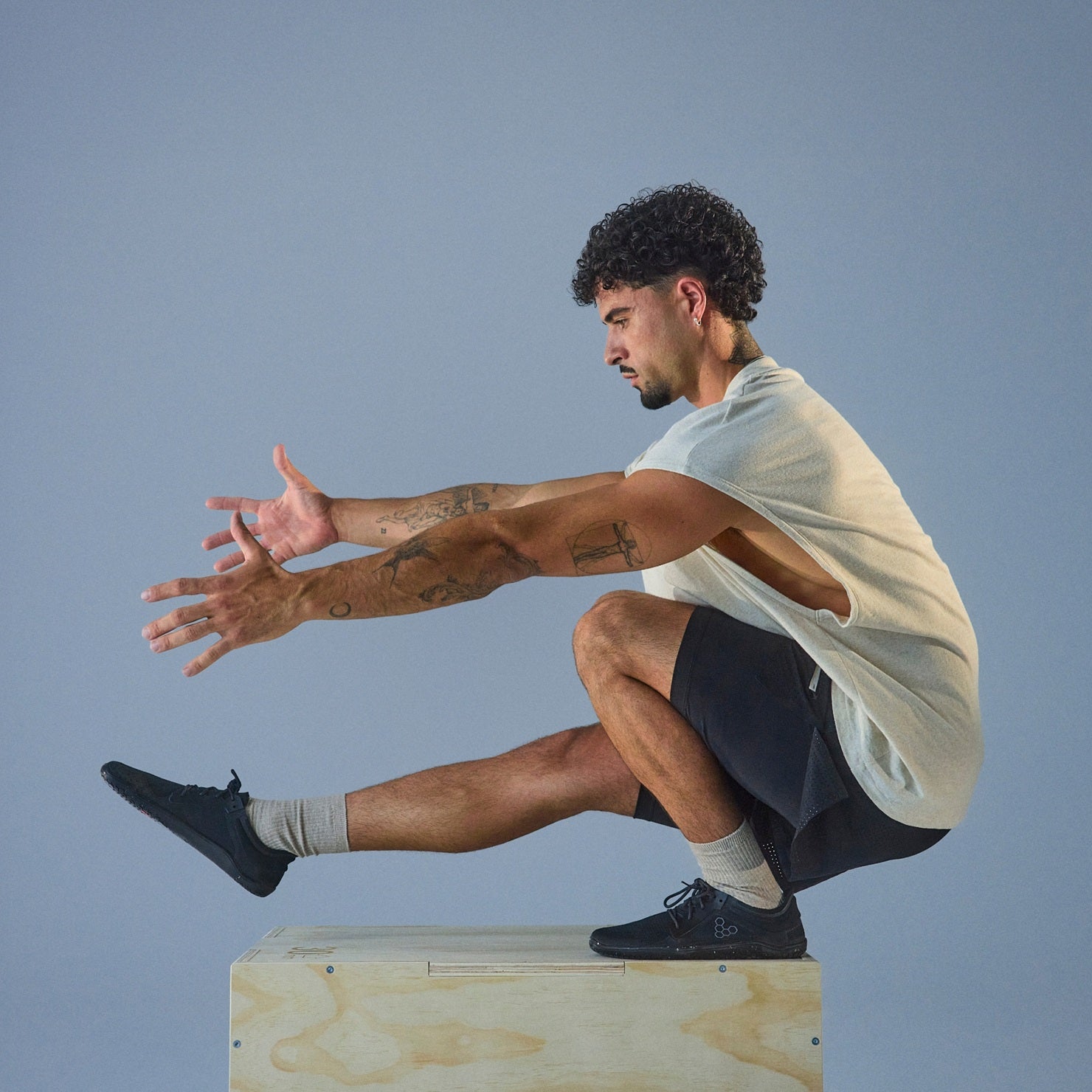 Man sitting on a box with a plain background