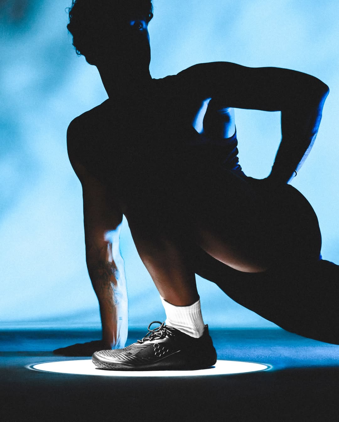 Silhouette of a person in athletic pose with blue background