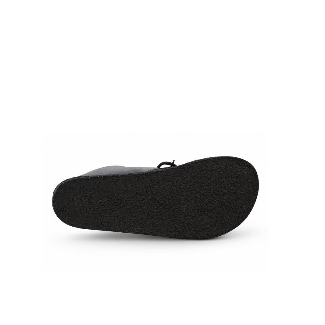 A close-up view of a black shoe sole, showing a textured rubber bottom and a small black loop detail, set against a plain white background.